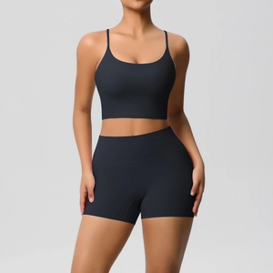 Close-up of black U-neck sports bra and high-waisted shorts set on model in studio