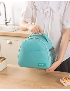 Mint green insulated lunch bag with mesh side pocket and durable top handles in a kitchen setting