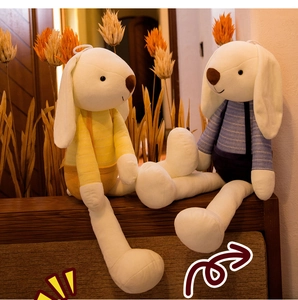 Close-up of soft plush rabbits wearing striped shirts and long ears sitting on wood