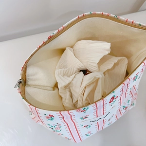 Vue détaillée du sac à maquillage à fleurs de fraises avec fermeture éclair et doublure