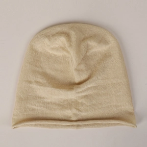 Close-up of beige 100% linen beanie showing fine knit texture and rolled edge detail