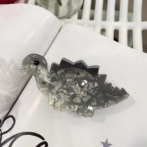 Top view of acrylic dinosaur hair claw clip with grey and white marble texture