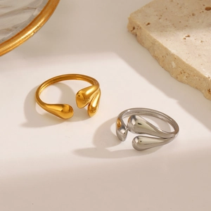 Polished gold and silver stainless steel teardrop rings shown from a 45-degree angle