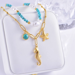 Detail of nautical layered necklace with turquoise beads and gold seahorse charms