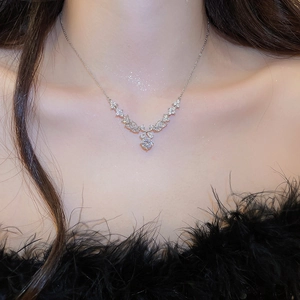 Close-up of V-shaped silver necklace with round zircon pendant on a fashion model