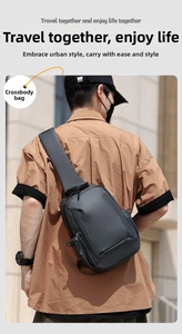Detail of waterproof crossbody bag with wide shoulder strap shown on a male model