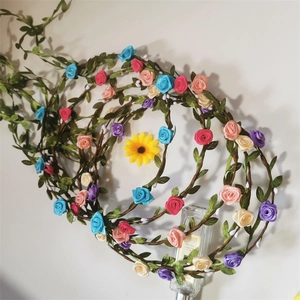 Detail showing artificial rose and sunflower flower vine headbands on wall display