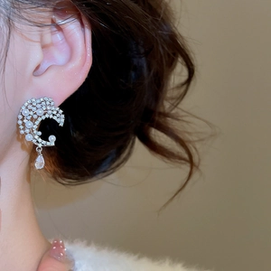 Detail of silver crescent moon pearl earrings with zircon water drop pendant on ear