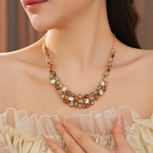 Close-up of vintage gold necklace with amber crystal drop worn on a female model