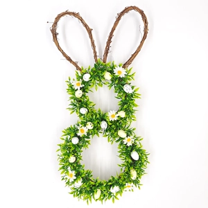 Detailed view of Easter bunny wreath with green leaves, daisies and speckled eggs