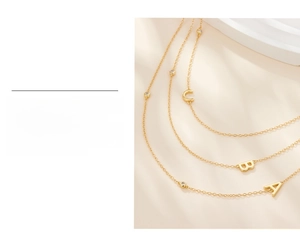 Detail view of gold-plated S925 silver letter pendants with micro-set zircon stones