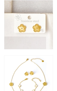 Detailed view of gold stainless steel jewelry set with white shell flower charms