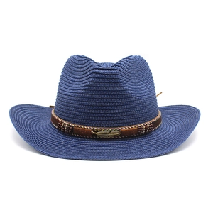 Detail of blue straw cowboy hat with brown braided band and gold feather ornament