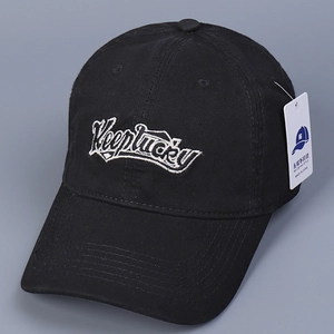 Detailed embroidery of Keeplucky lettering on black cotton twill baseball cap