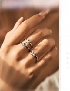 Close-up of three stacked S925 silver rings with pear and round cut moissanite on hand