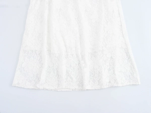 Vue détaillée du zoom sur l'ourlet en dentelle florale de cette élégante robe longue blanche