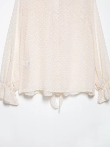 Detail der cremeweißen transparenten Bluse mit Polka-Dot-Jacquard und Taillenband
