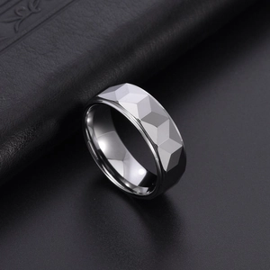 Vue macro d'une bague en carbure de tungstène gris argenté taillée sur fond de cuir