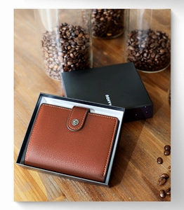 Brown leather wallet in black gift box with vintage coffee bean background and logo detail