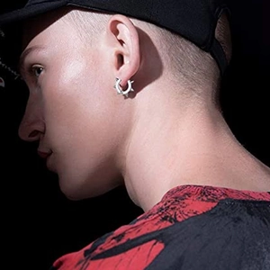 Punk style silver spike ear cuff on model with a high-contrast dark background