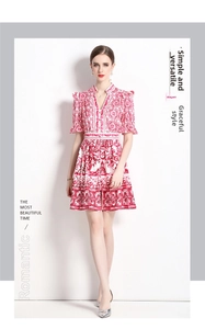 Detail of red floral tile print on a V-neck dress with ruffled puff sleeves and buttons