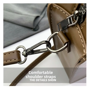 Detail shot of brown leather strap with dark grey metal hook and neat stitching