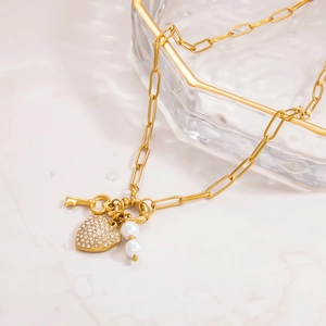 Elegant gold paperclip chain necklace with sparkling heart pendant, key and pearls