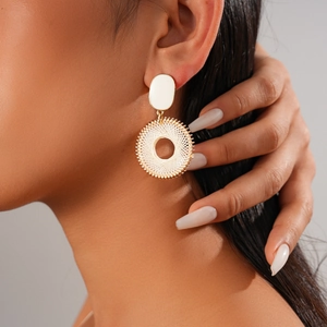Detail view of pearl geometric hoop earring with gold accents worn by a model