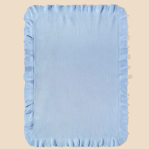 Macro detail of soft light blue knit baby blanket with elegant ruffled edge texture