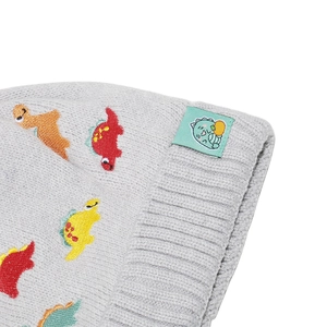 Close-up of knit ribbing and colorful dinosaur embroidery on a gray children's beanie