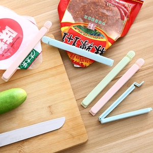 Set of 5 large plastic food bag sealing clips in multiple colors on a wooden surface