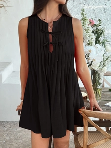 Detail of the black sleeveless pleated mini dress with tie-front detail and soft fabric