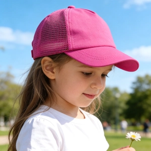 Nahaufnahme einer rosaroten atmungsaktiven Kinder-Mesh-Baseballkappe im Park-Ambiente