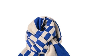Detailed view of a blue and beige checkered knit scarf tied in a stylish knot on white background