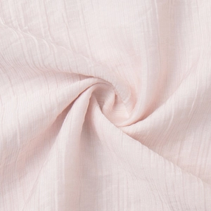 Detail of light pink seersucker fabric showing soft pleated texture and airy material