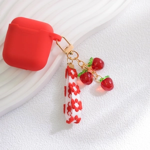 Detailed view of red silicone earphone case with cherry charm and woven strap