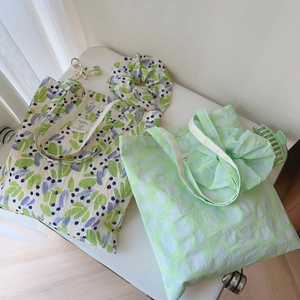 Detail of printed cotton tote bag and matching scrunchie with floral and polka dot patterns