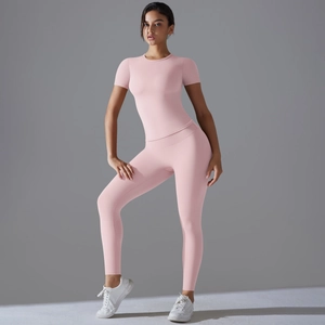 Dettaglio del top rosa aderente a maniche corte e dei pantaloni da yoga a vita alta