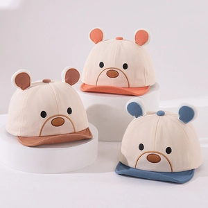 Detailed view of three soft-brim baby baseball caps with cute 3D bear ears on stands