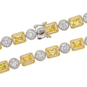 Detailed close-up of golden and silver bracelet with yellow and clear zircon stones