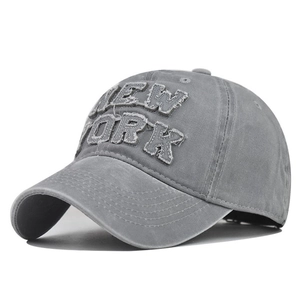 Detailed view of NEW YORK embroidery on vintage washed cotton baseball cap texture