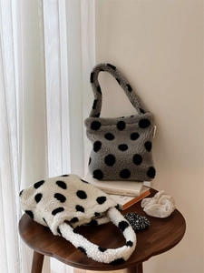 Vue détaillée de sacs cabas en peluche à pois avec chouchous assortis posés sur une table