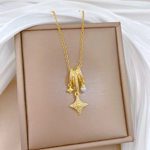 Detailed shot of gold titanium necklace with pearl, star pendants and crystal rings