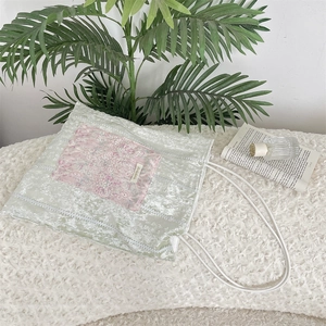 Close-up of velvet tote bag with pink lace embroidery and delicate green fabric texture
