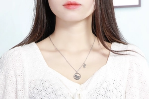 Détail du collier avec pendentif cheval à bascule argenté porté par un mannequin