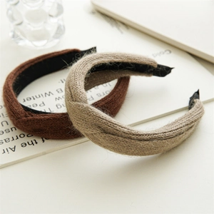 Detail showing two knitted knotted headbands in classic brown and beige wool fabric