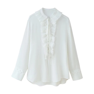Detailed close-up of white long sleeve shirt with ruffled collar and decorative neck ties