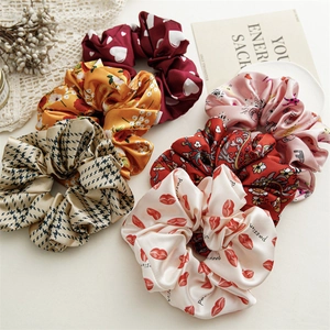 Detail showing a 6-piece set of satin scrunchies with floral and houndstooth patterns