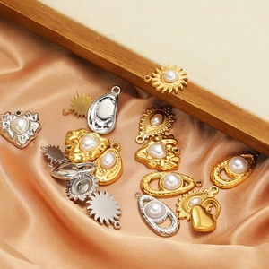 Stainless steel pearl pendants in sun and heart shapes on champagne silk background