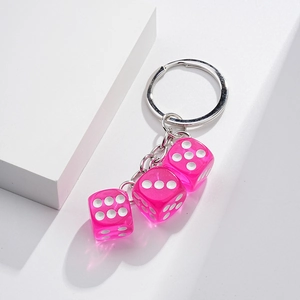 Close-up of pink transparent dice keychain on metallic chain with minimalist white background